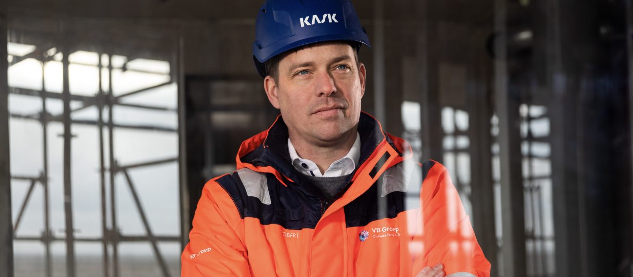 Algemeen directeur Robert van Boldrik kijkt vanaf een bouwproject naar buiten