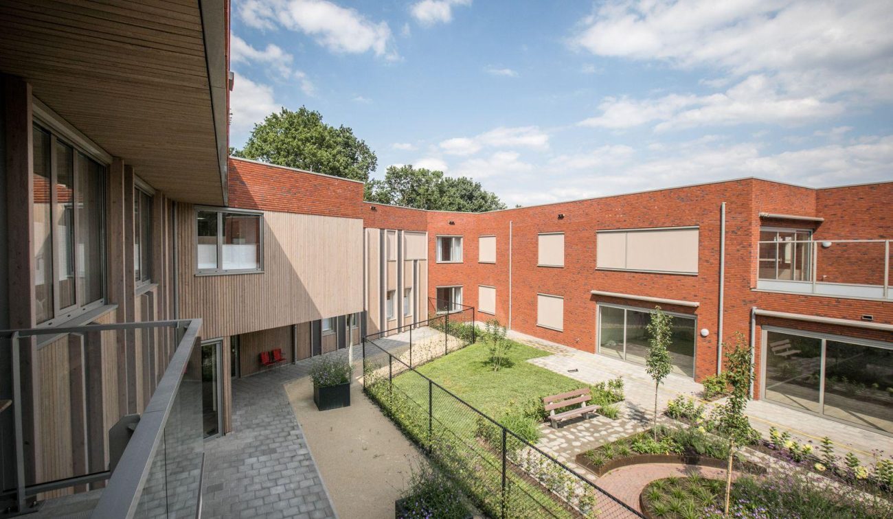 Uitzicht vanaf de tweede etage van het nieuwbouwcomplex met het GZC en de zorgwoningen, met zicht op de tuin en omliggende gebouwen.