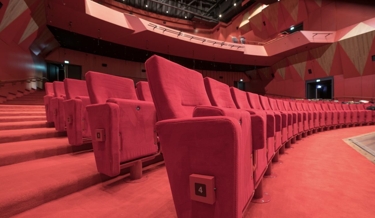 Verbouwing Theater aan het Vrijthof Maastricht: rij rode pluche stoelen in vernieuwde zaal met balkon