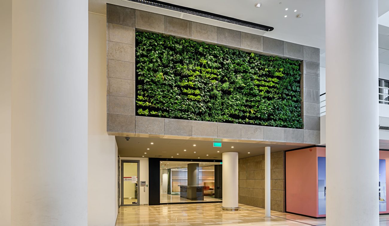 Stiltecentrum Hoog Catharijne: vernieuwde entree met groene wand, witte kolommen en natuursteen vloer