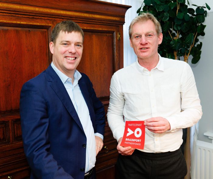 Robert van Boldrik (links) samen met een vertegenwoordiger van het Brainport Partnerfonds (rechts), die een embleem in zijn handen heeft