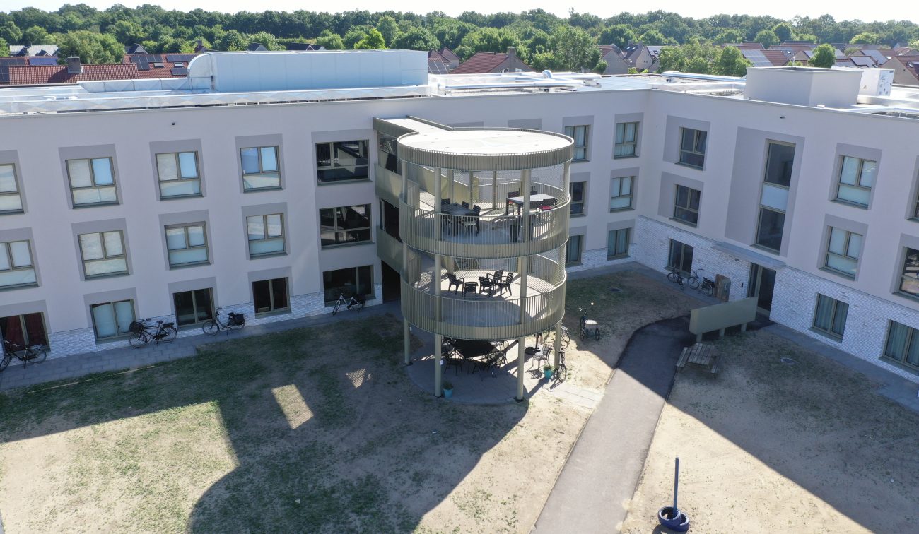Ronde balkontoren bij zorgwoningen Risselthof Horst, binnenhof met pad en gras