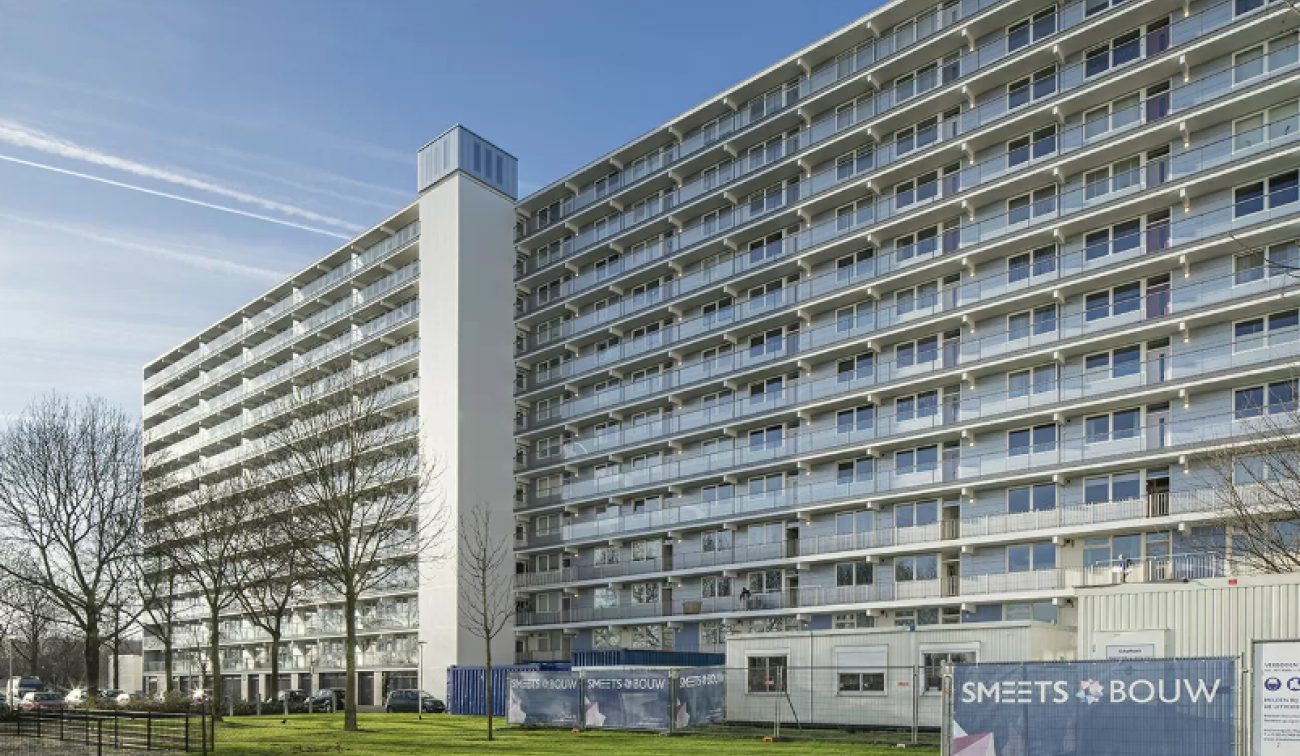 Gerenoveerde galerijflat Heerlerbaan Heerlen met glazen balkonhekken en witte trappentoren.