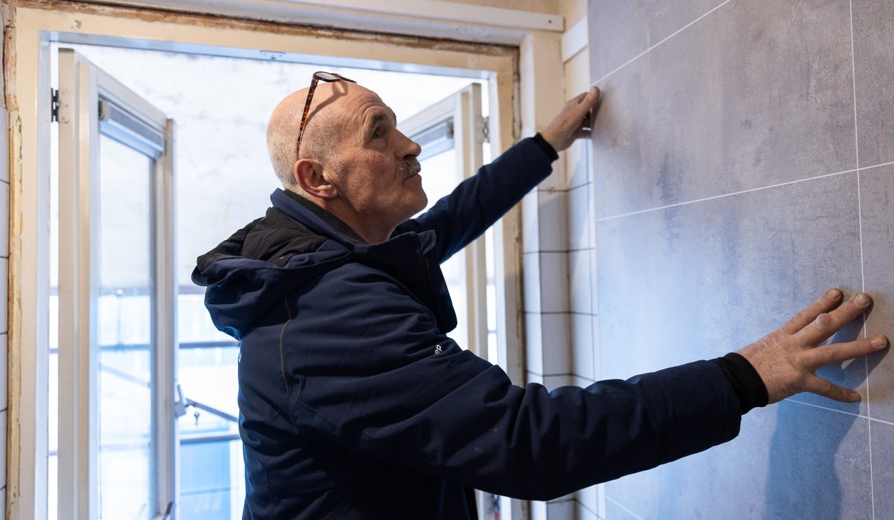 Vakman controleert tegelwerk in een woning in de wijk Tuinzigt Haagpoort tijdens het groot onderhoudsproject.