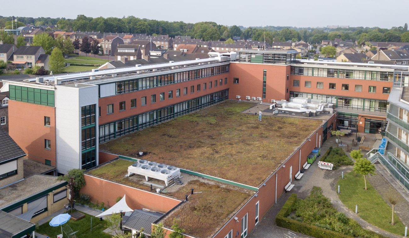 Luchtfoto zorgcentrum Aan de Bleek Schinveld: groendak binnencour, installaties en rode baksteengevels