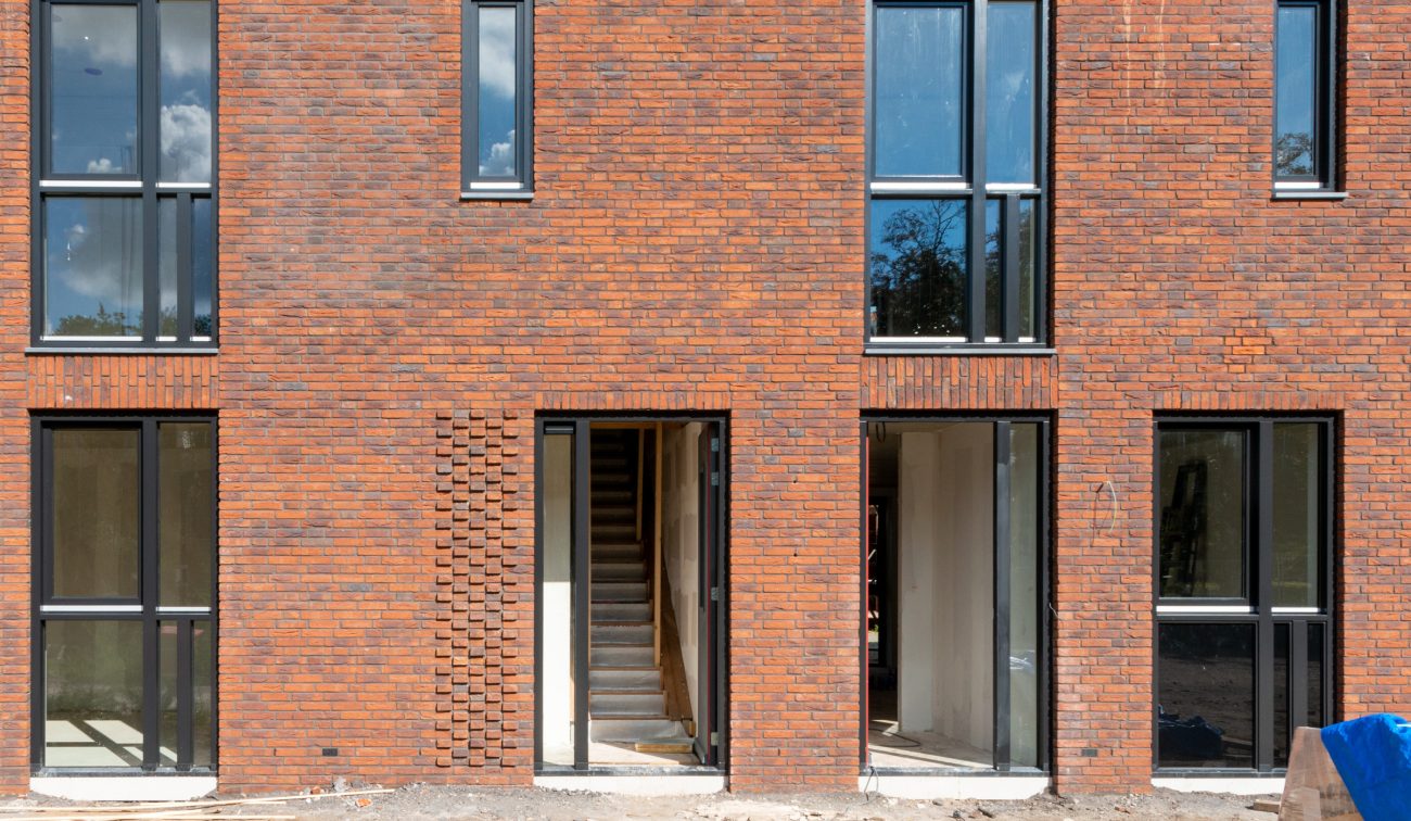 Kloostervelden Sterksel – geveldetail in rood baksteen met verdiept metselwerk, entree naar trap en hoge smalle ramen in bouwfase