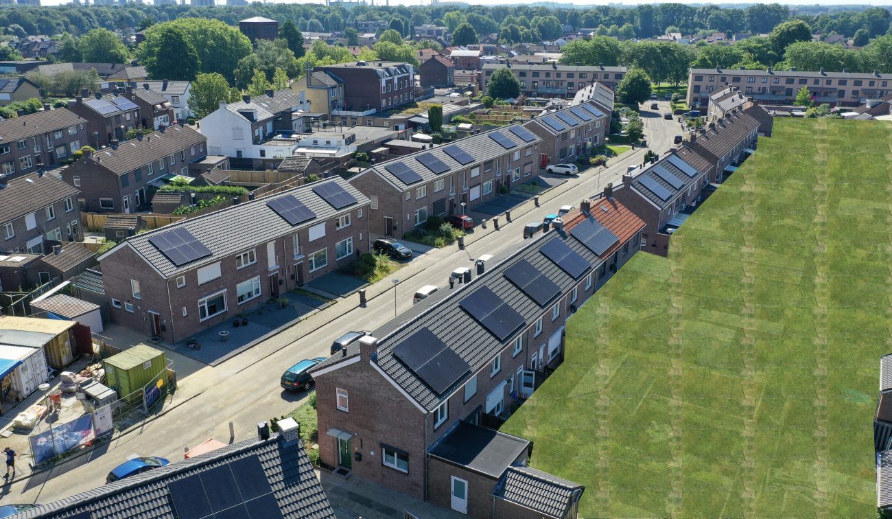 Woonstraat in Nieuwdorp met bakstenen rijtjeshuizen, pv-panelen en geparkeerde auto’s — Groot onderhoud 154 woningen Nieuwdorp Stein
