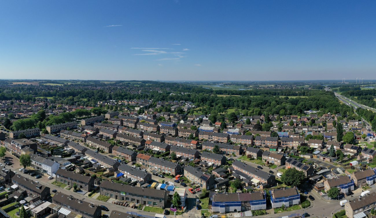 Vogelvlucht over woonwijk in Stein met aaneengesloten rijtjeshuizen, bomen en infrastructuur — Groot onderhoud 154 woningen Nieuwdorp Stein
