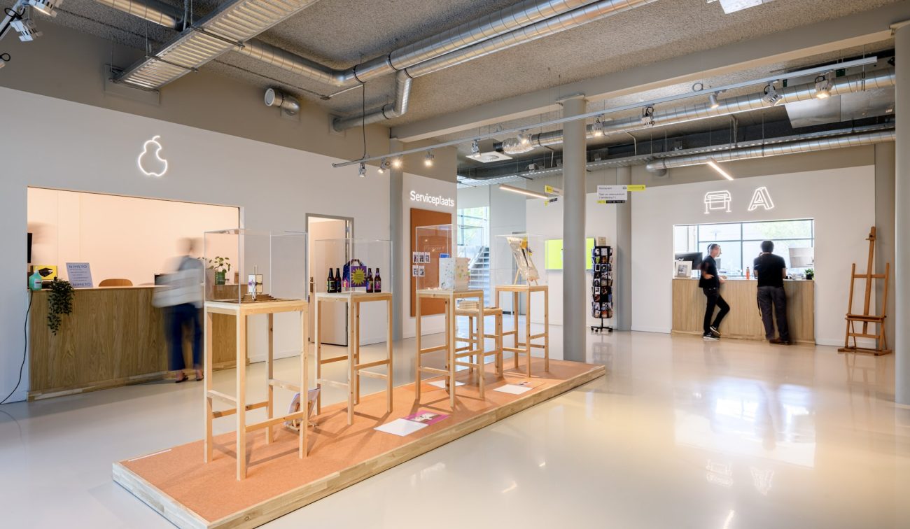 Servicepunt in modern schoolinterieur; studenten bij loket, gepolijste vloer en spotverlichting.