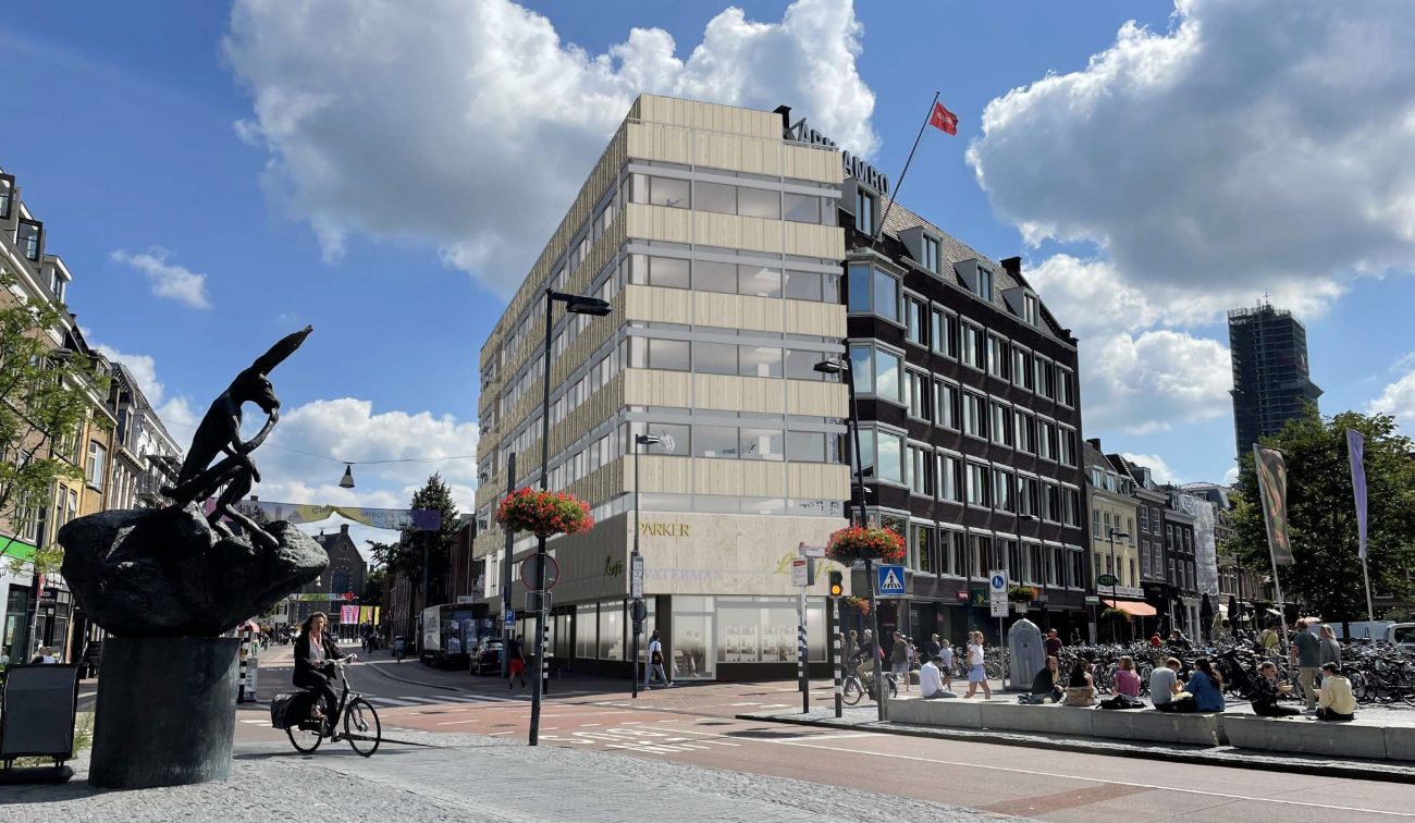 Gevel van een kantoorpand midden in een stad met blauwe lucht en bewolking