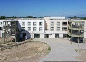 Nieuwbouw zorgwoningen Risselthof Horst met lichte gevel en ronde balkontorens.