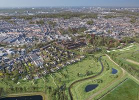 Vogelperspectief van landgoed met omliggend parklandschap en woonwijk aan de stadsrand