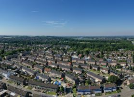 Vogelvlucht over woonwijk in Stein met aaneengesloten rijtjeshuizen, bomen en infrastructuur — Groot onderhoud 154 woningen Nieuwdorp Stein