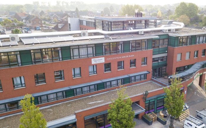 Luchtfoto renovatie zorgcentrum Aan de Bleek Schinveld: rood metselwerk, groene kozijnen, pv-panelen